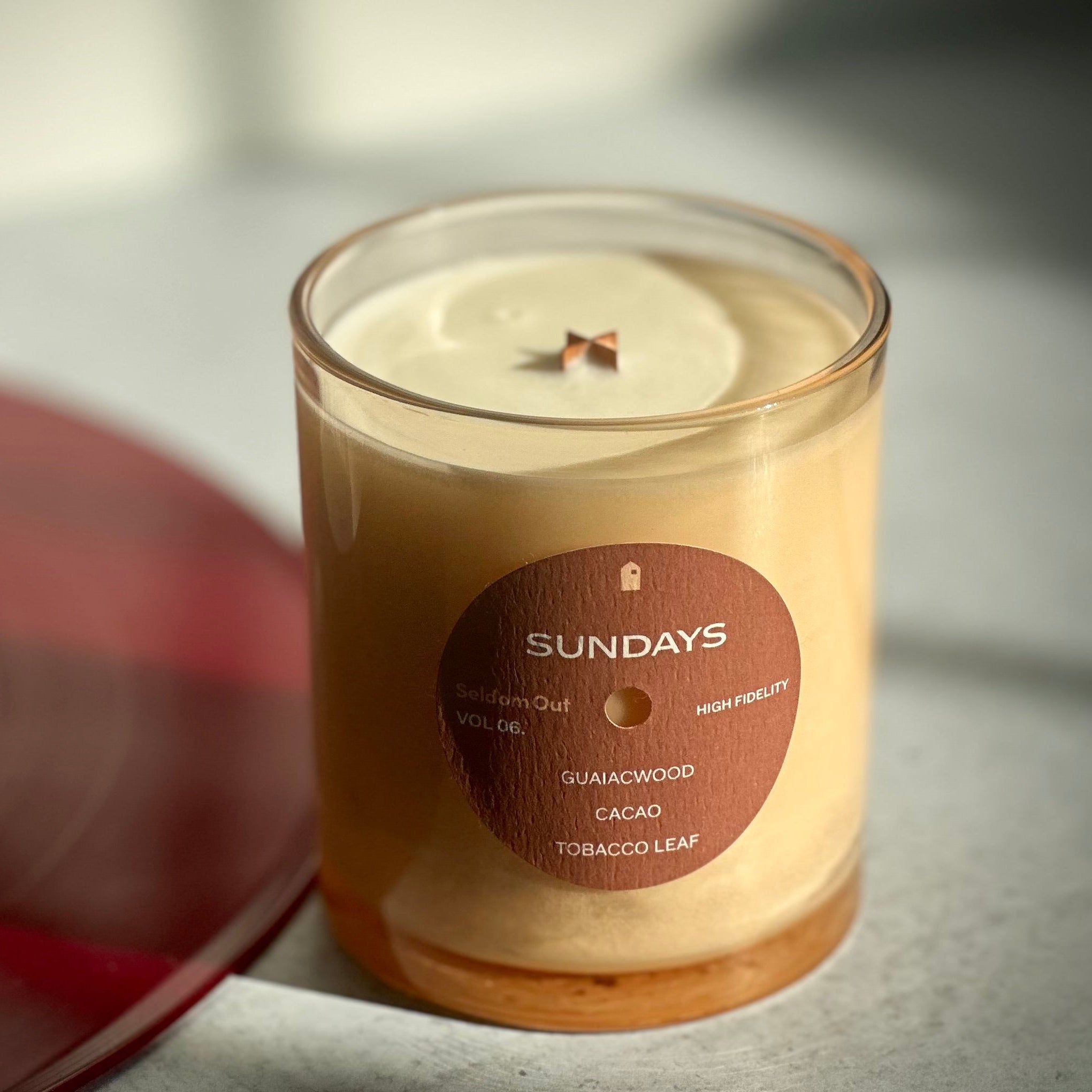 Candle with a label on a concrete surface, with a blurred background