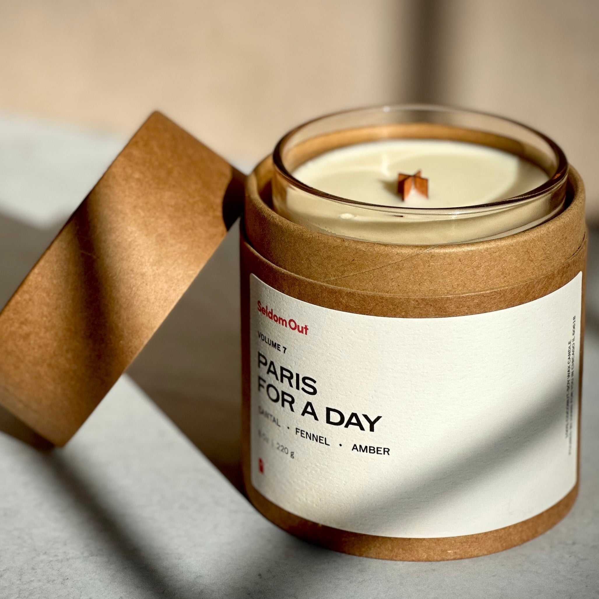Candle in a kraft paper sleeve with a label on a neutral background