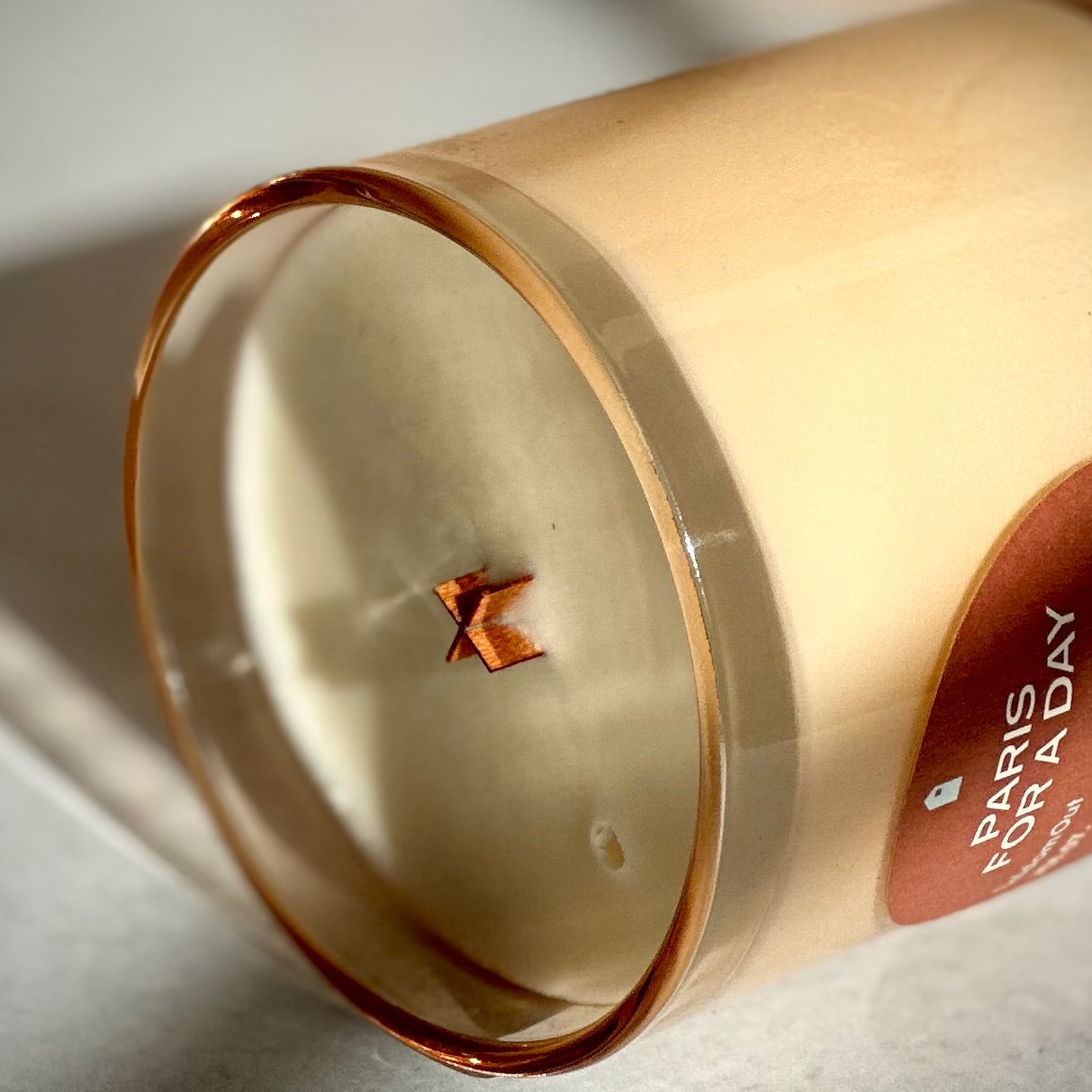 Candle with a visible brand label on a light background