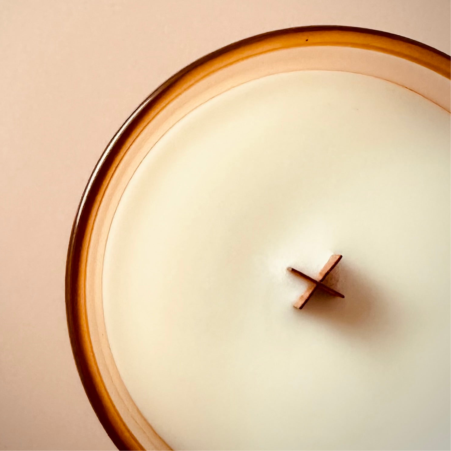 An overhead photo of our 8oz Dreamwave candle highlighting the wooden X shaped wick.