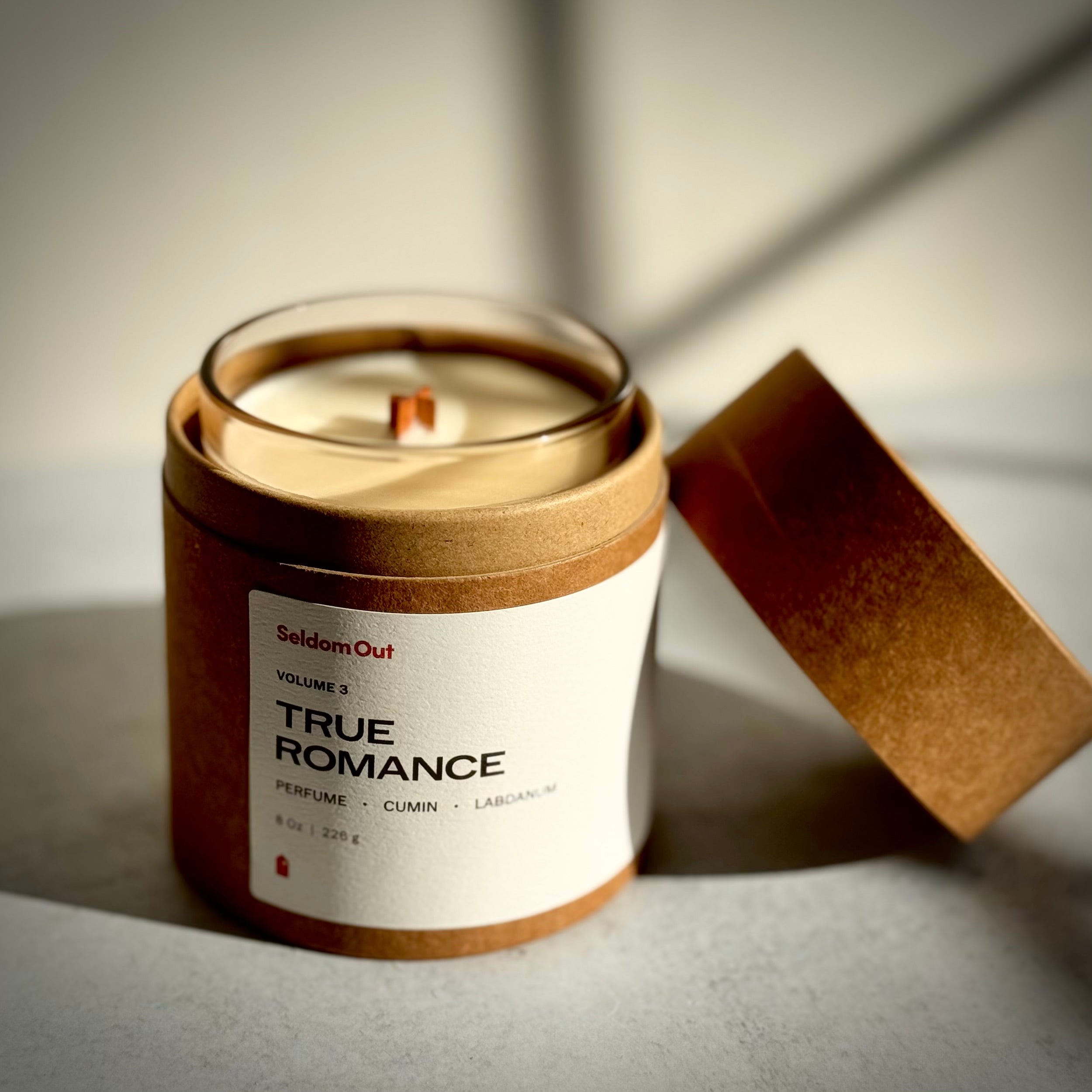 A portrait of our 8oz True Romance Candle shown in it's brown kraft paper tube packaging against a neutral background.
