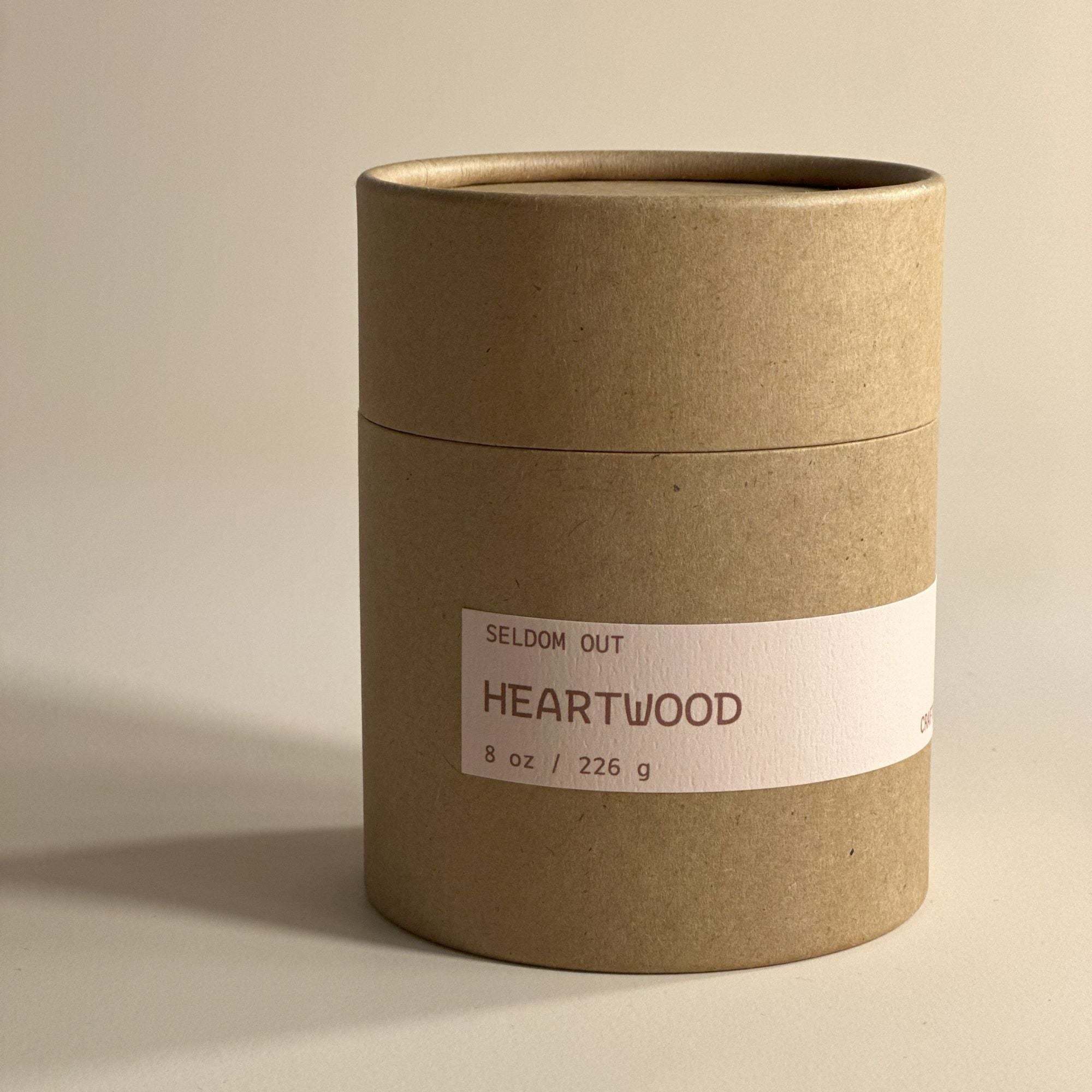 A portrait image of the Kraft Tube Box packaging for our 8oz Heartwood scented candle. It has a long thin label that matches the scented candle.