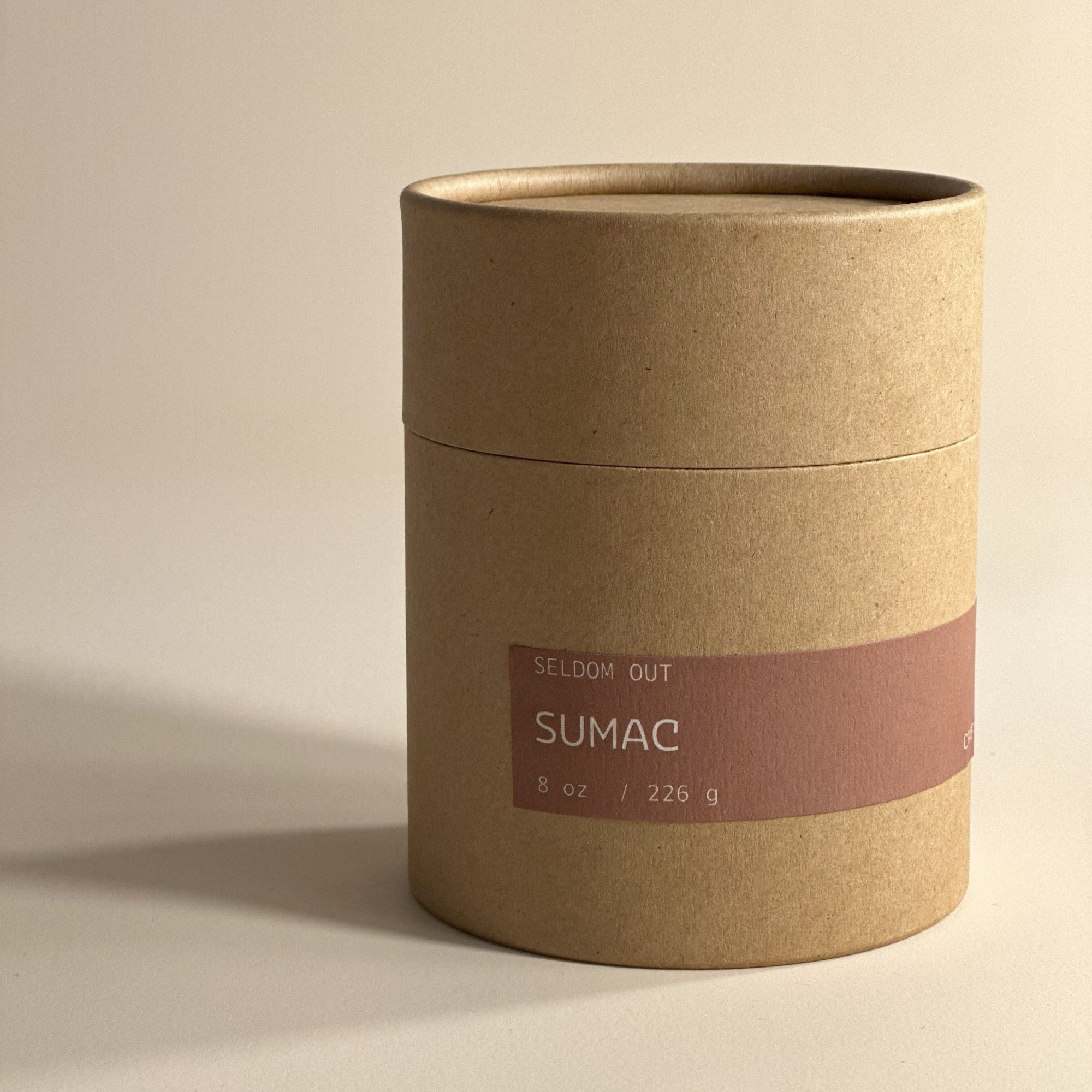 A portrait image of the tube box for our 8oz Sumac scented candle. Made with sturdy Kraft paperboard it features a long thin label.